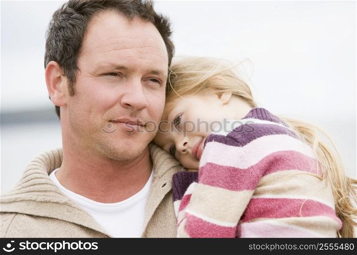 Father holding daughter at beach