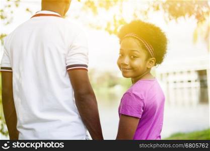 Father holding hands of daughter - African American family