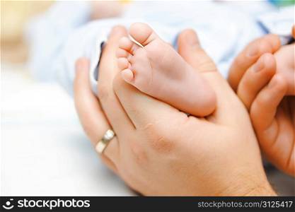 Father holding his newbon baby&acute;s feet