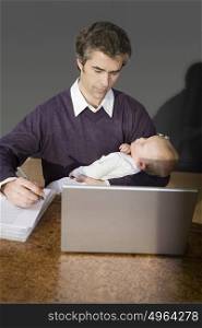father holding his son and working