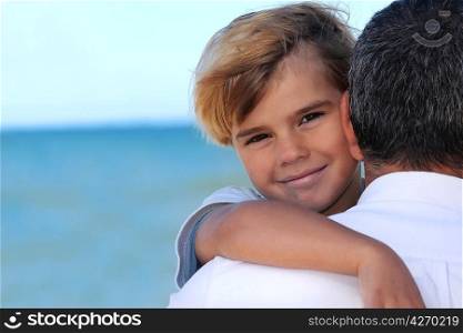 father holding his son on the beach