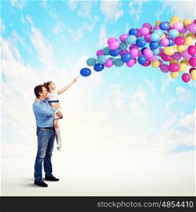 Father holding on hands daughter. Image of happy father holding on hands daughter and balloons