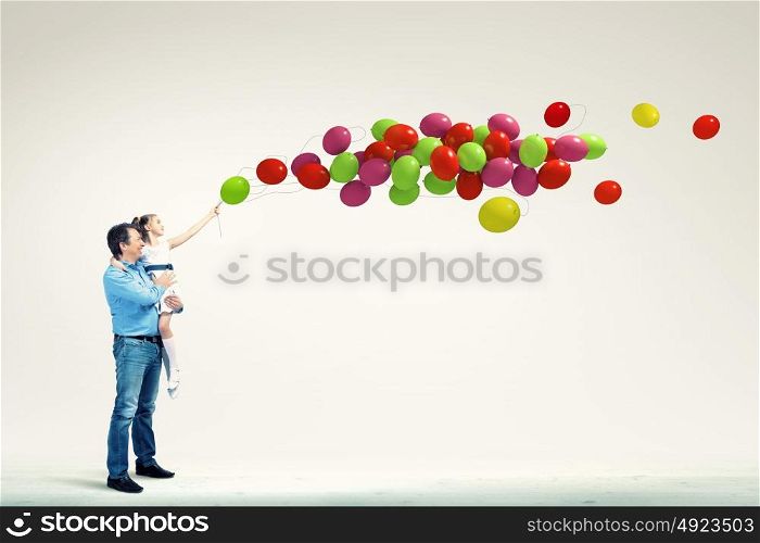 Father holding on hands daughter. Image of happy father holding on hands daughter and balloons