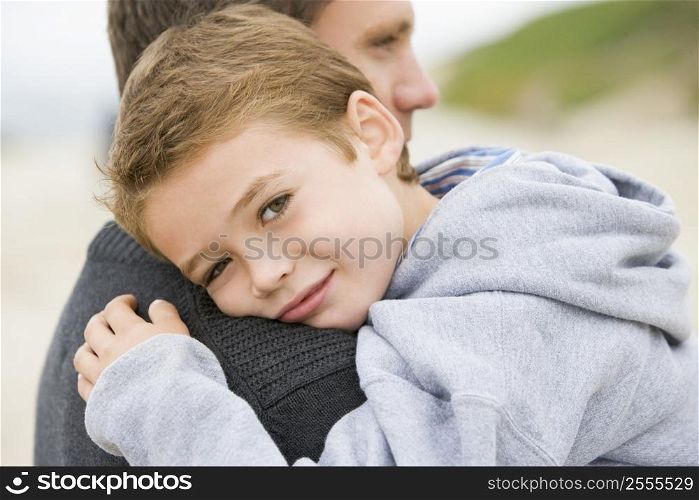 Father holding son at beach