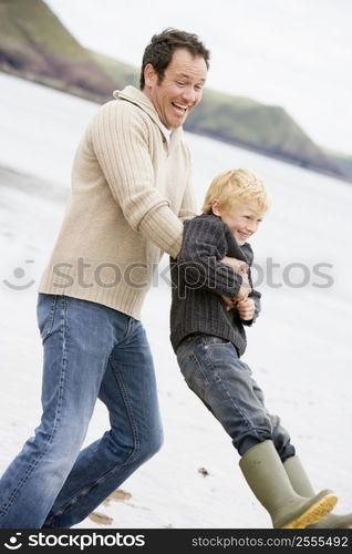 Father holding son at beach smiling