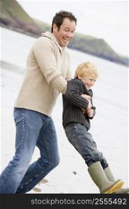 Father holding son at beach smiling