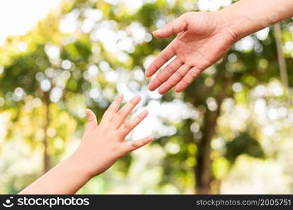 Father holding son&rsquo;s hand in a public garden