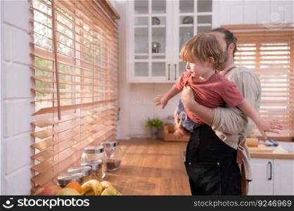 Father in the kitchen of the house with a small child. Play and have fun cooking dinner together.