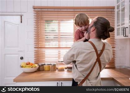 Father in the kitchen of the house with a small child. Play and have fun cooking dinner together.