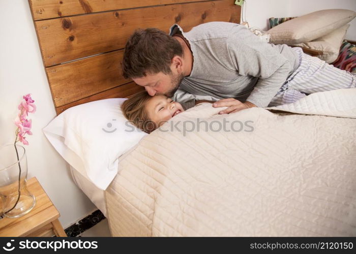 father kissing his daughter s forehead before going sleep