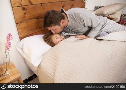 father kissing his daughter s forehead before going sleep