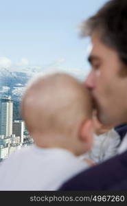 father kissing his sons head