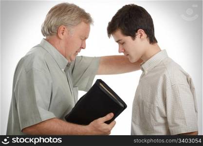 Father leading his son in prayer to receive Jesus