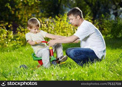 Father learns the son to go by a bicycle, outdoor