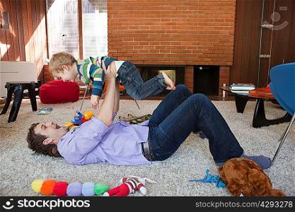 Father lifting son in living room