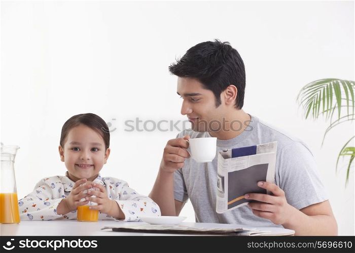 Father looking at daughter while having breakfast