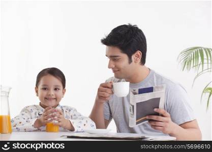 Father looking at daughter while having breakfast