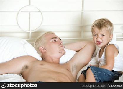 Father lying on the bed looking at his son