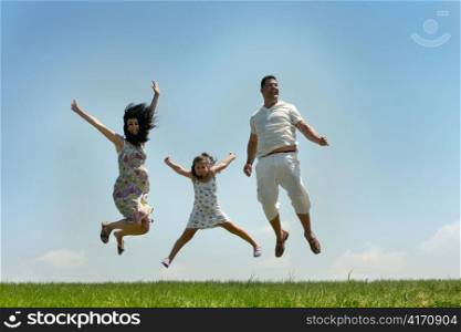 Father, mother and daughter fly on blue sky