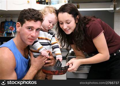 father, mother, child and frying pan on the kitchen