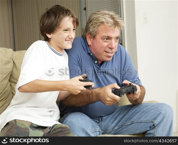 Father or uncle playing video games with a little boy - his son or nephew.