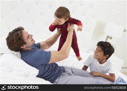 Father Playing In Bed With Children