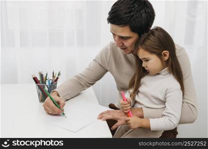 father playing with crayons with daughter