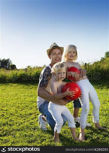 Father playing with daughters outdoors