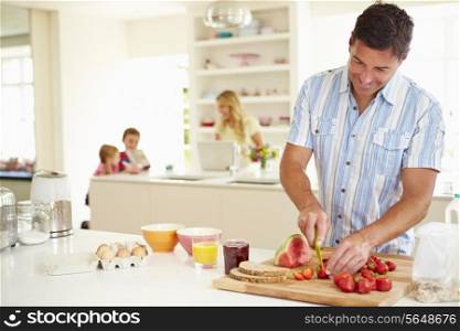 Father Preparing Family Breakfast In Kitchen