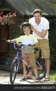 Father Putting Saftey Helmet On Son Before Bike Ride
