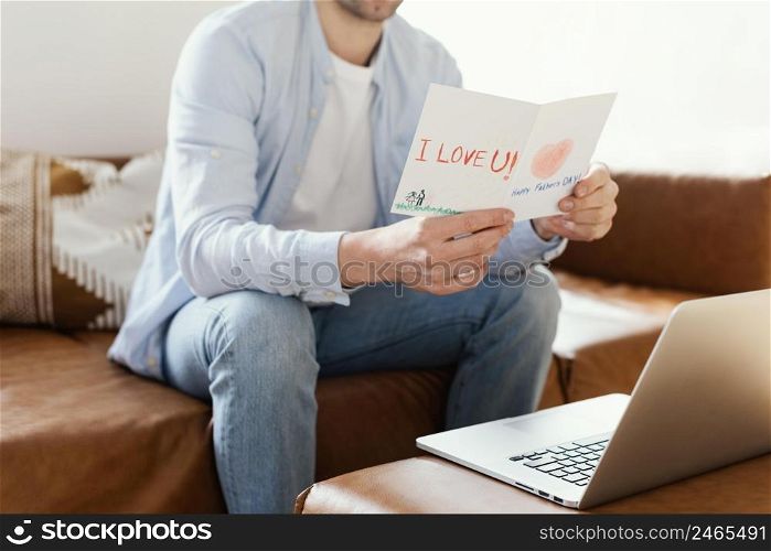father reading his father s day card while working laptop