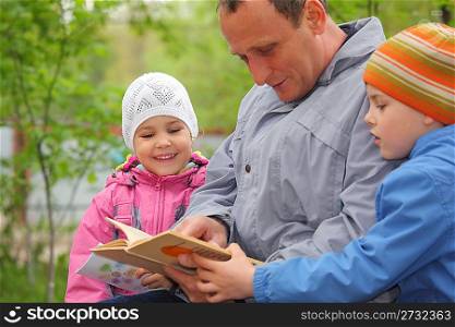 father reads book for kids, focus on little girl