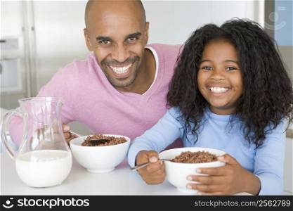 Father Sitting With Daughter As She They Eat Breakfast