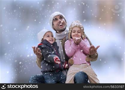 Father sitting with kids as it snows