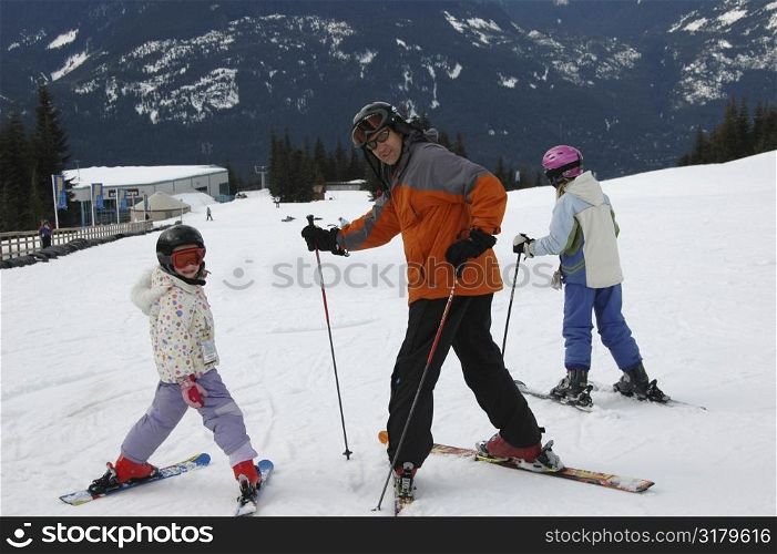 Father skiing with his daughters