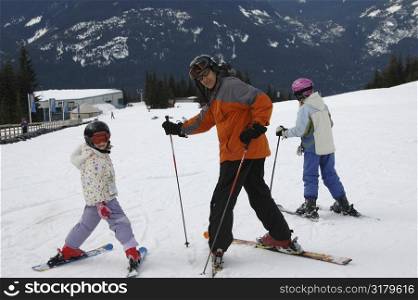 Father skiing with his daughters