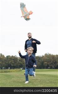 father son playing with kite front view