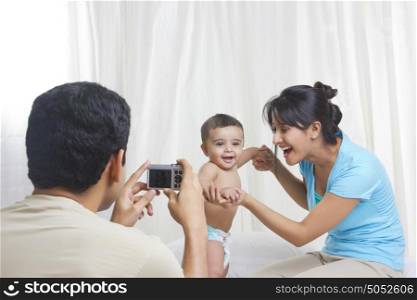 Father taking picture of mother and baby