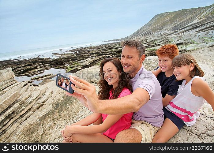 Father taking picture of the family in front of the sea