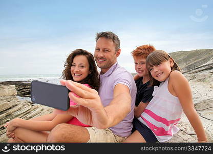 Father taking picture of the family in front of the sea