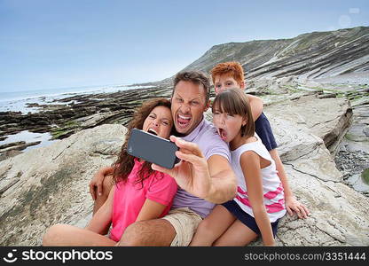 Father taking picture of the family in front of the sea