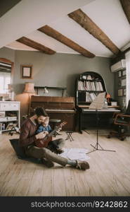 Father teaching daughter to play guitar in the room at home