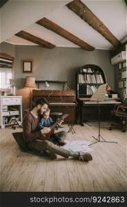 Father teaching daughter to play guitar in the room at home