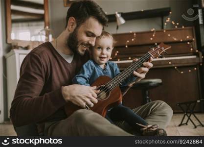 Father teaching daughter to play guitar in the room at home
