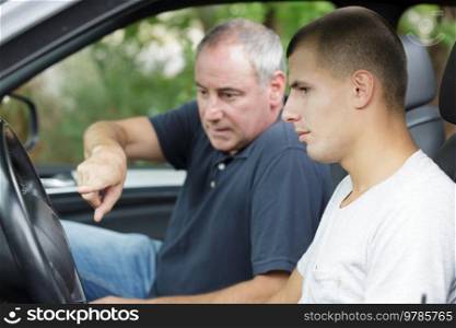 father teaching his son to drive a car