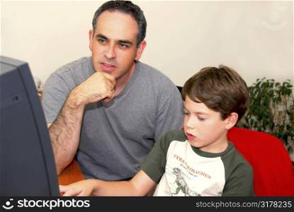 Father teaching his son to work on a computer