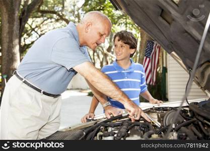 Father teaching his young son how to repair the car.