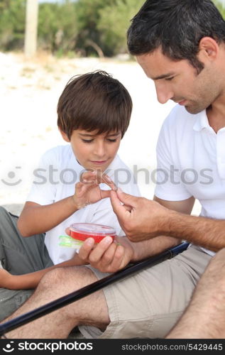 Father teaching his young son to fish
