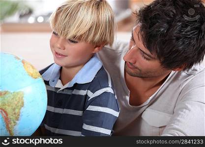 Father teaching little boy about different countries