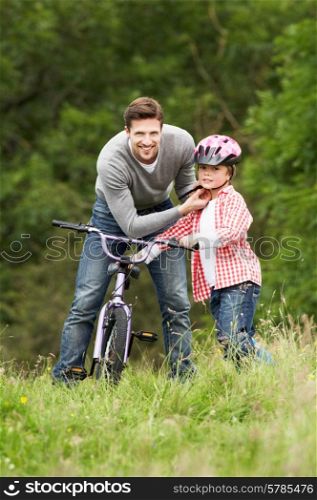 Father Teaching Son To Ride Bike In Countryside